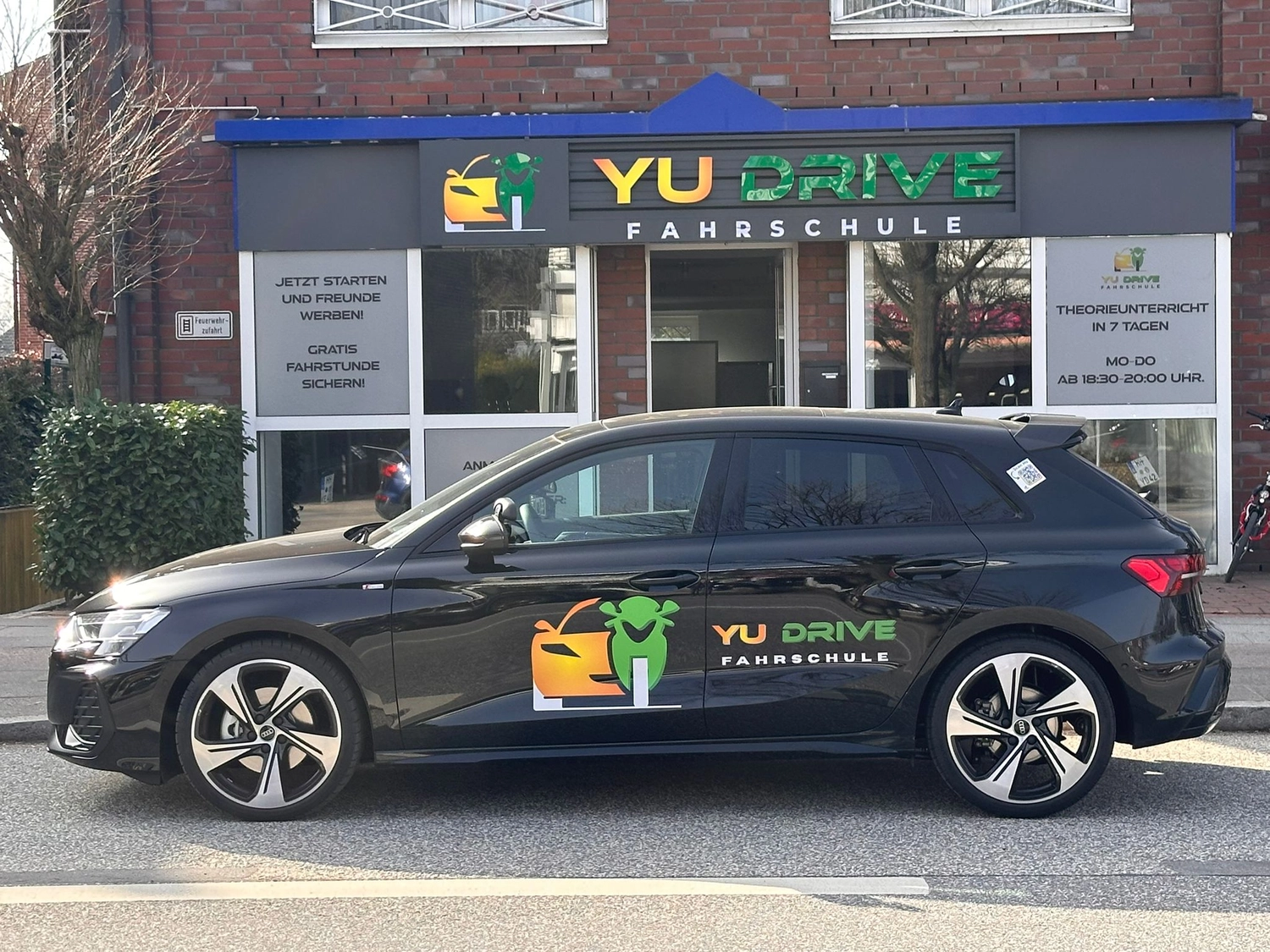Fahrschulauto von Yu Drive vor der Fahrschule